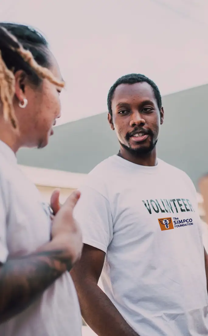 A SIMPCO Foundation volunteer with a community member